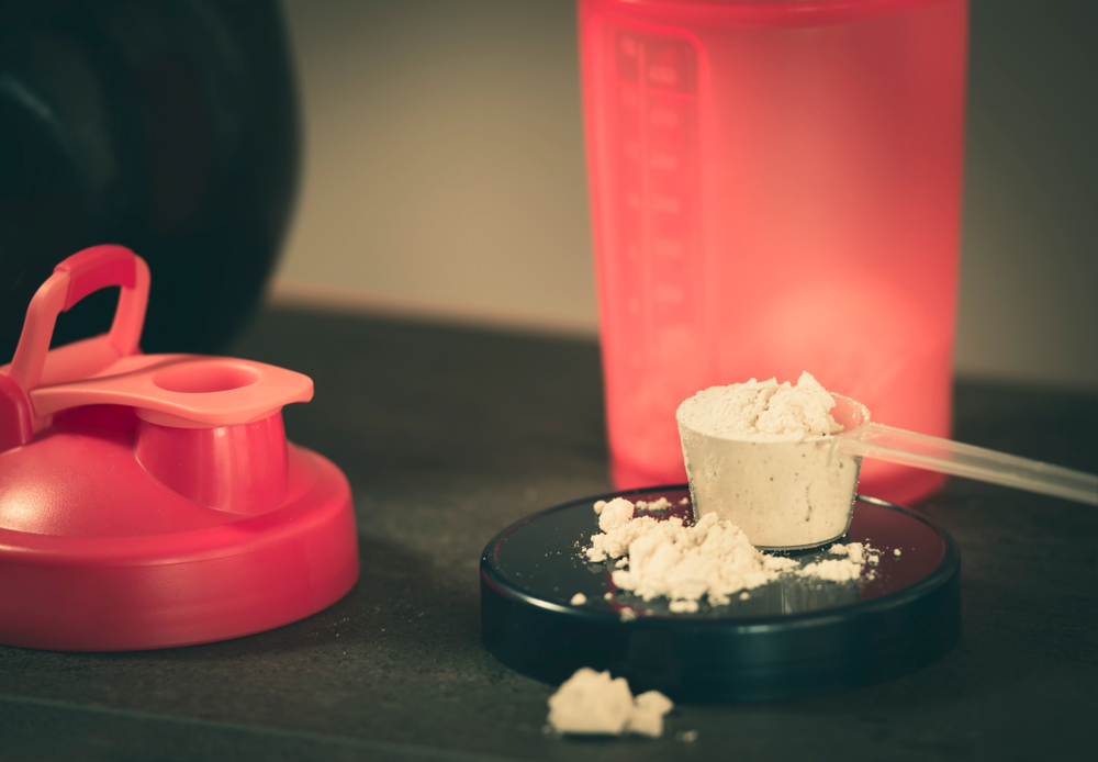 protein powder in a measuring cup and a sports  cup
