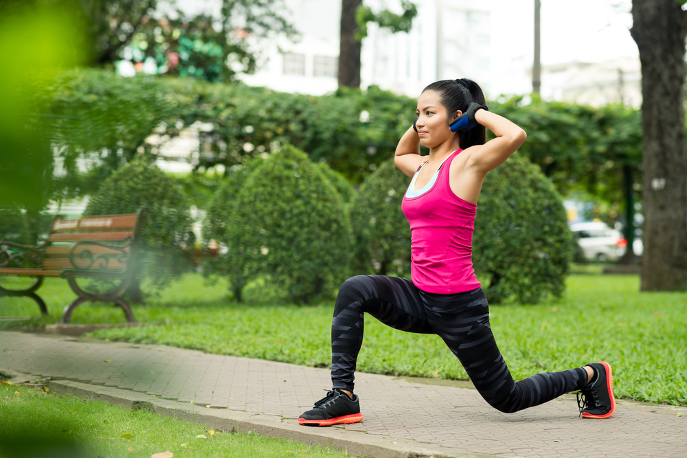 woman doing lunges in a park